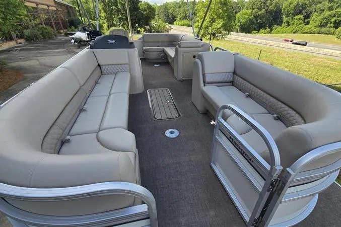 Slide: The Image of 2023 Ranger Reata 223C pontoon boat with spacious seating and scenic outdoor view. - 6
