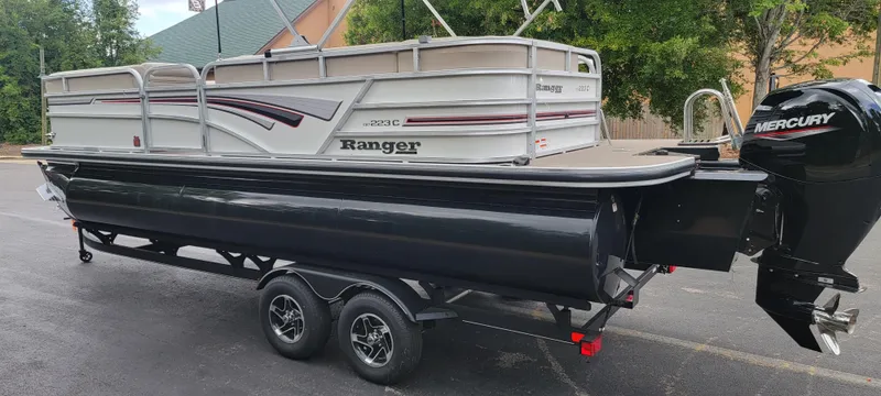 Slide: The Image of A Ranger Reata 223C pontoon boat on a trailer, parked in a lot. - 8
