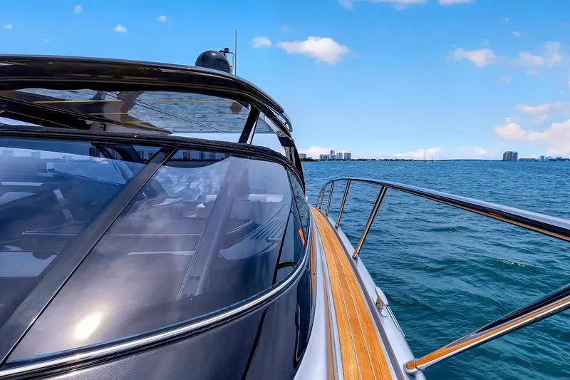 Slide: The Image of 2022 Riva 56' Rivale yacht cruising on open water under a clear blue sky. - 22