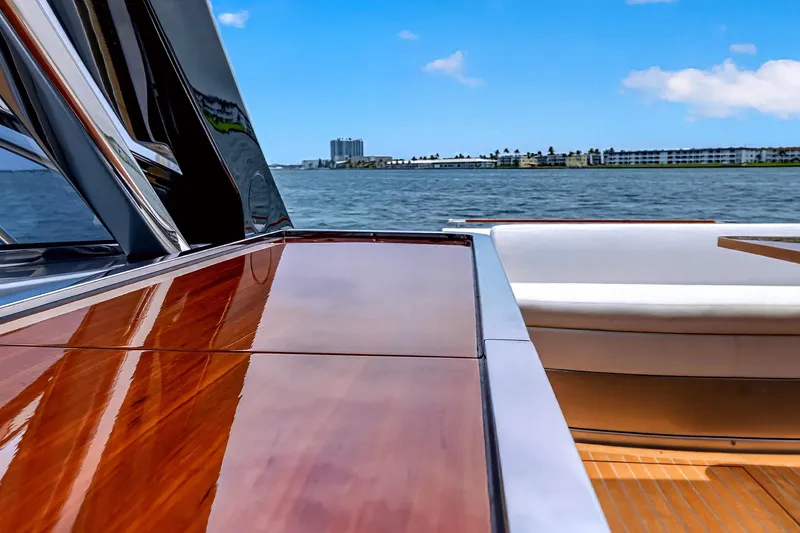 Slide: The Image of Luxurious 2022 Riva 56' Rivale yacht with polished wood deck, overlooking serene waters. - 29
