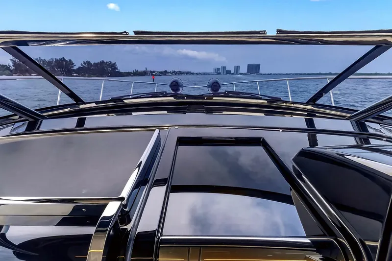 Slide: The Image of 2022 Riva 56' Rivale yacht cruising on open water with city skyline in background. - 36