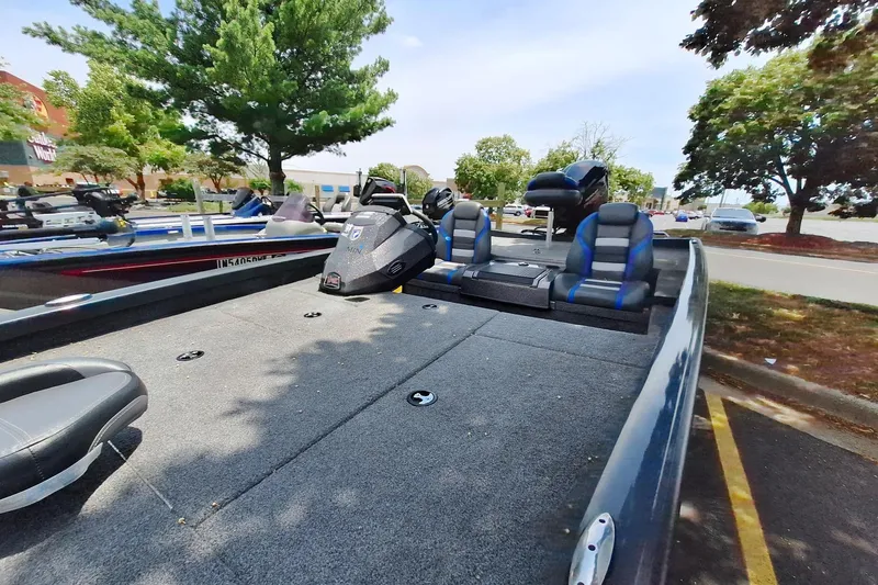 Slide: The Image of 2021 Boomeranger RT188P boat with dual seats, parked outdoors under trees. - 2