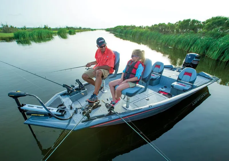 Slide: The Image of Two people fishing on a Tracker boat in calm waters. - 16