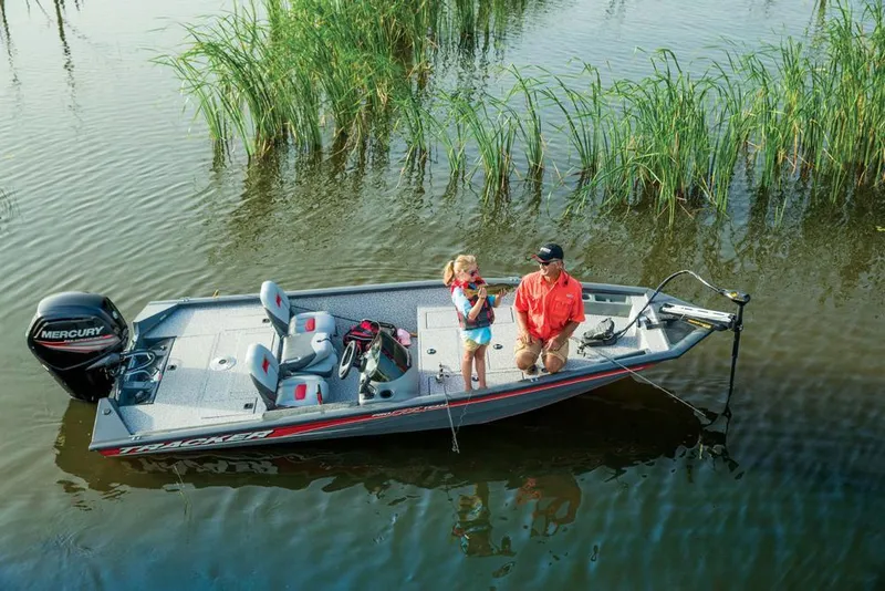 Slide: The Image of A boat with two people fishing in calm water with reeds. - 19