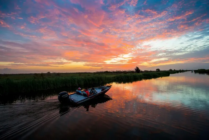 Slide: The Image of A boat navigates a calm river at sunset. - 29