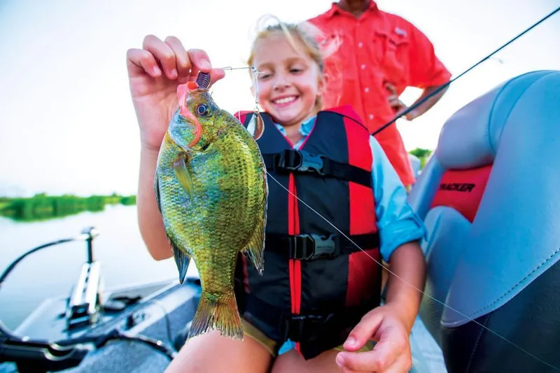 Slide: The Image of A child holds a fish on a boat, smiling and happy. - 30