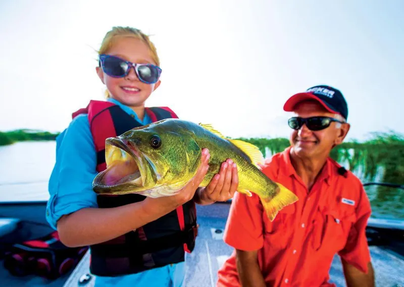 Slide: The Image of A child holds a large fish on a boat, accompanied by an adult. - 35