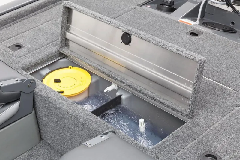 Slide: The Image of An open storage compartment on a gray boat with a yellow lid and water. - 42