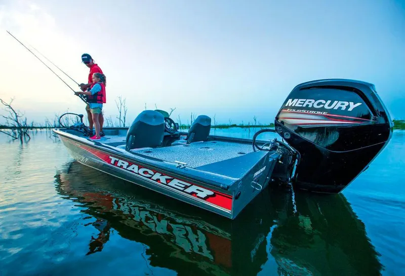 Slide: The Image of An angler stands on a Tracker boat on calm water. - 8