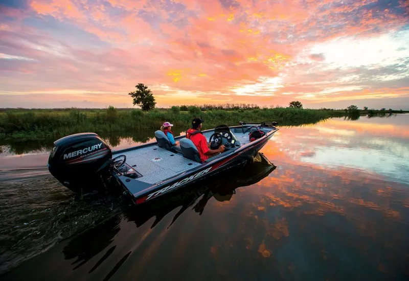 Slide: The Image of Two people ride in a boat on calm water during a vibrant sunset. - 9