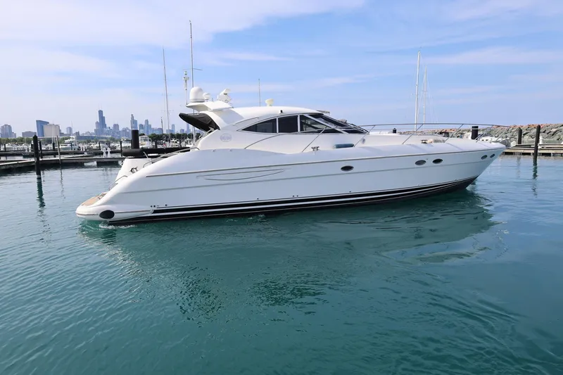 The Image of 1999 Neptunus 54 Express yacht docked in marina with city skyline backdrop. - 0