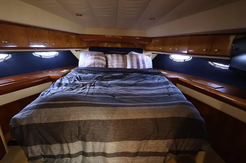 Slide: The Image of Luxurious cabin interior of 1999 Neptunus 54 Express yacht with cozy bed and wooden cabinetry. - 16
