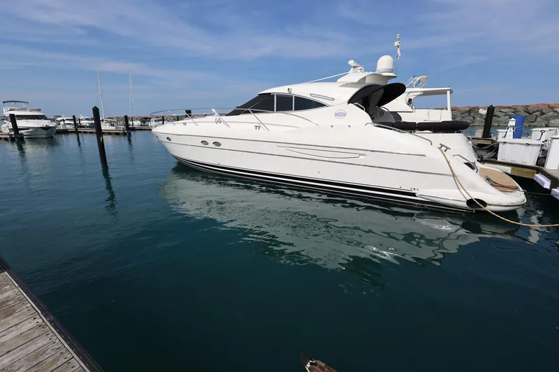 Slide: The Image of 1999 Neptunus 54 Express yacht docked in a marina under a clear blue sky. - 2