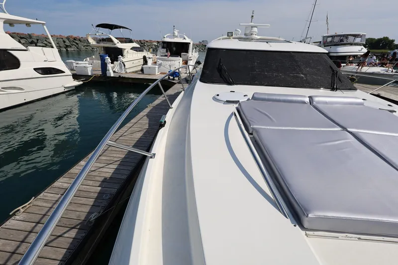 Slide: The Image of 1999 Neptunus 54 Express yacht docked at marina, featuring sleek design and sunbathing area. - 5