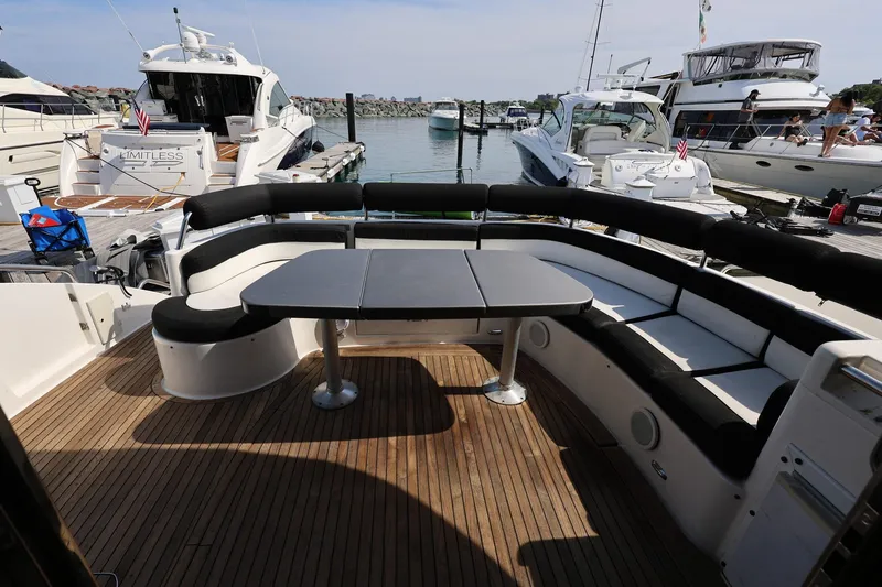 Slide: The Image of 1999 Neptunus 54 Express yacht with spacious deck seating and table, docked at marina. - 6