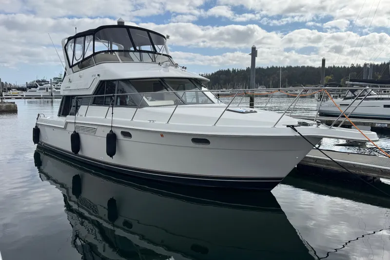 Slide: The Image of 1996 Carver 370 Voyager yacht docked in a marina, reflecting on calm water. - 1