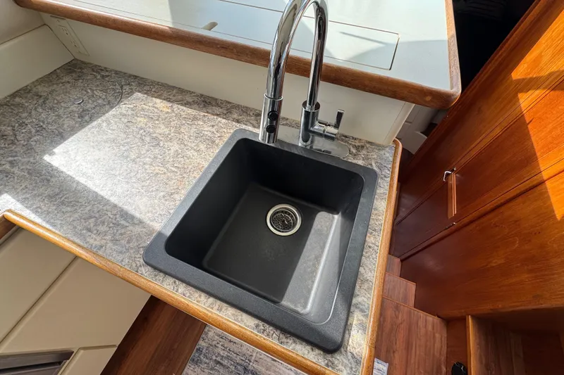 Slide: The Image of Kitchen sink in 1996 Carver 370 Voyager yacht with marble countertop and wooden cabinetry. - 14