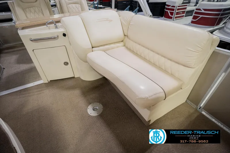 Slide: The Image of 2013 Bennington 2550 RBR boat interior with cream leather seating and storage compartment. - 32