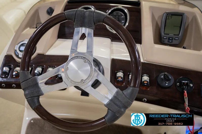 Slide: The Image of Steering wheel and dashboard of a 2013 Bennington 2550 RBR boat, featuring control panels. - 38