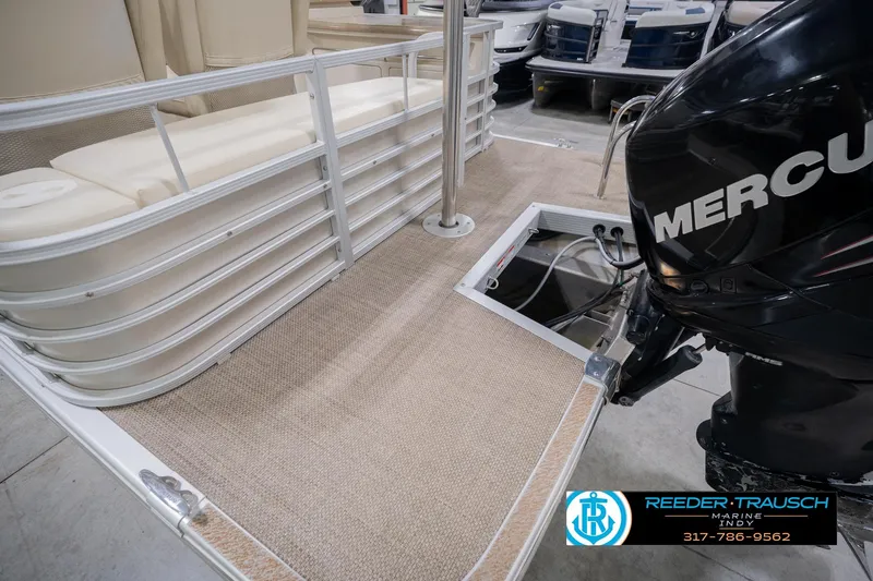 Slide: The Image of 2013 Bennington 2550 RBR pontoon boat with Mercury engine, beige seating, and carpeted deck. - 68