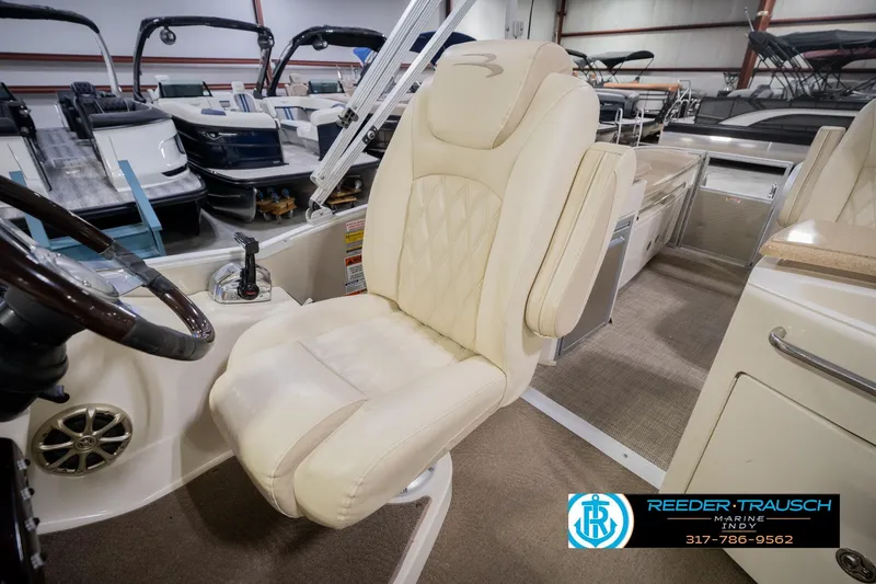 Slide: The Image of Captain's chair in a 2013 Bennington 2550 RBR pontoon boat, showroom setting. - 34