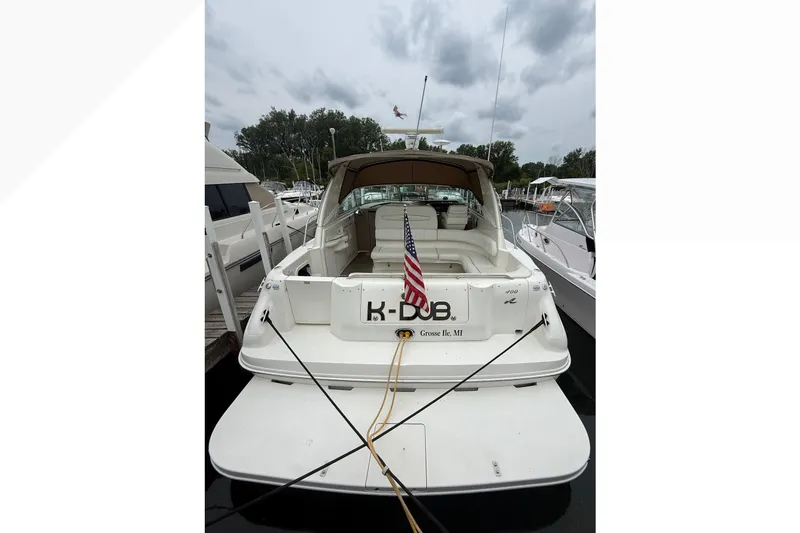 Slide: The Image of 1998 Sea Ray Sundancer 400 docked, rear view with American flag, overcast sky. - 10