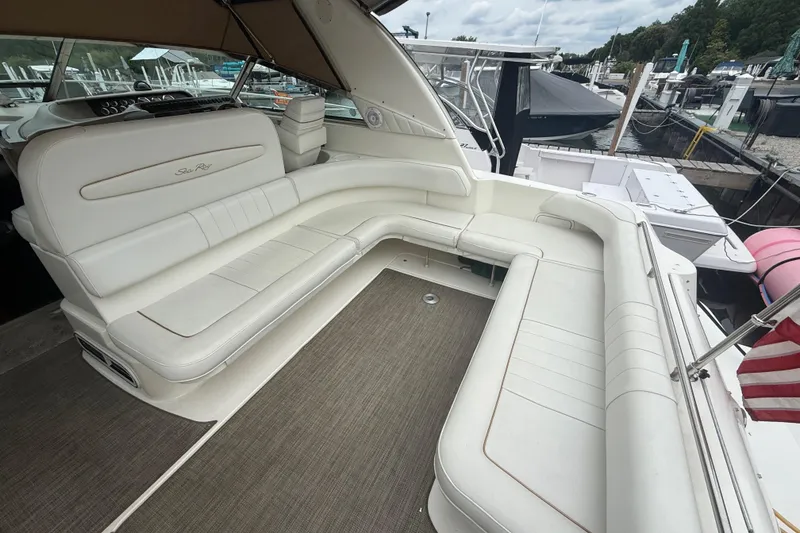 Slide: The Image of 1998 Sea Ray Sundancer 400 yacht with spacious white seating at a marina. - 11