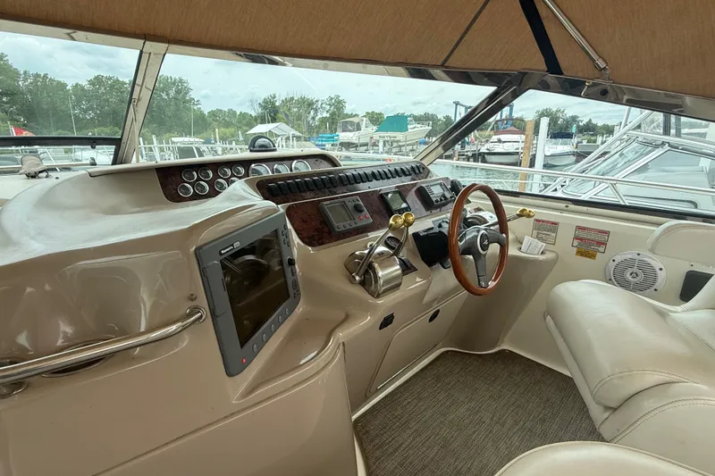 Slide: The Image of 1998 Sea Ray Sundancer 400 helm with steering wheel, controls, and navigation equipment. - 17