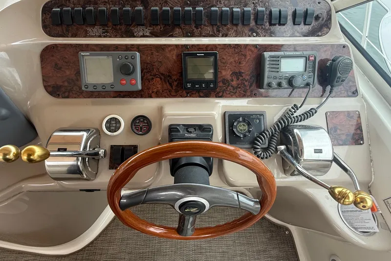 Slide: The Image of 1998 Sea Ray Sundancer 400 helm with wood steering wheel and navigation controls. - 18
