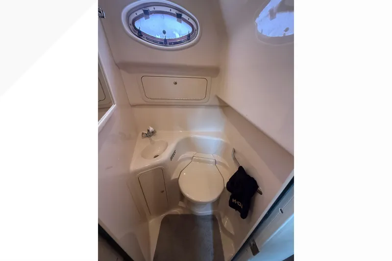 Slide: The Image of 1998 Sea Ray Sundancer 400 yacht bathroom with sink, toilet, and porthole window. - 38