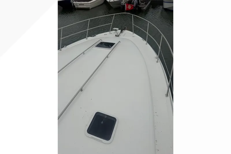 Slide: The Image of 1998 Sea Ray Sundancer 400 yacht deck with railing and hatches, docked in marina. - 4