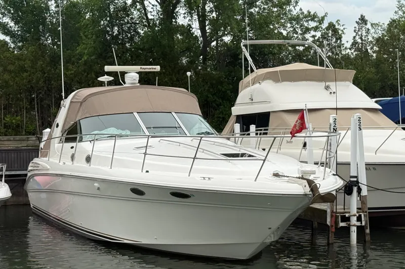 Slide: The Image of 1998 Sea Ray Sundancer 400 yacht docked in a marina, surrounded by trees. - 44