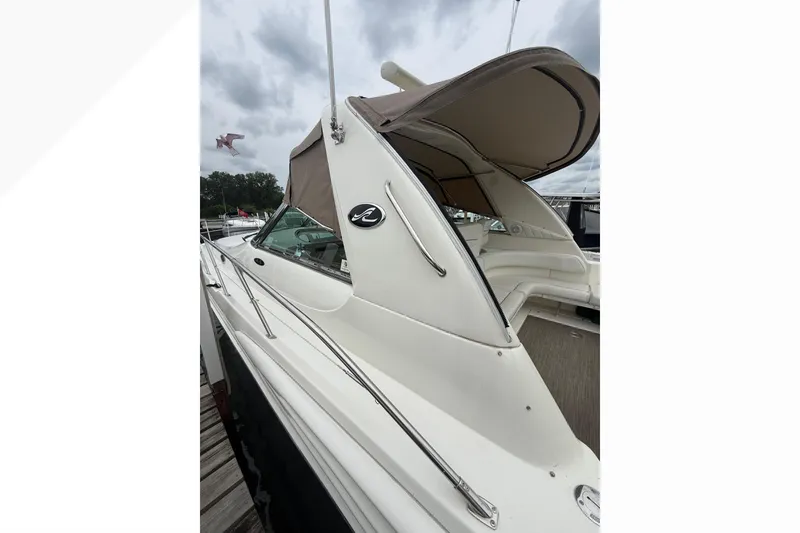 Slide: The Image of 1998 Sea Ray Sundancer 400 yacht with beige canopy, docked under cloudy skies. - 7