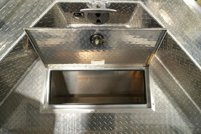 Slide: The Image of An open storage compartment on an aluminum boat with a non-slip surface. - 28