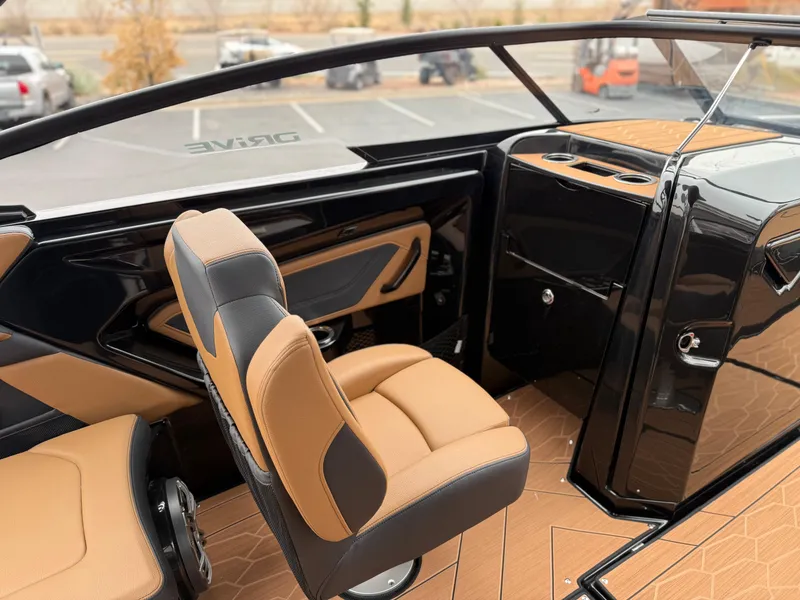 Slide: The Image of Interior of 2025 Yamaha Boats 255XD, featuring sleek black and tan seating and modern design. - 28