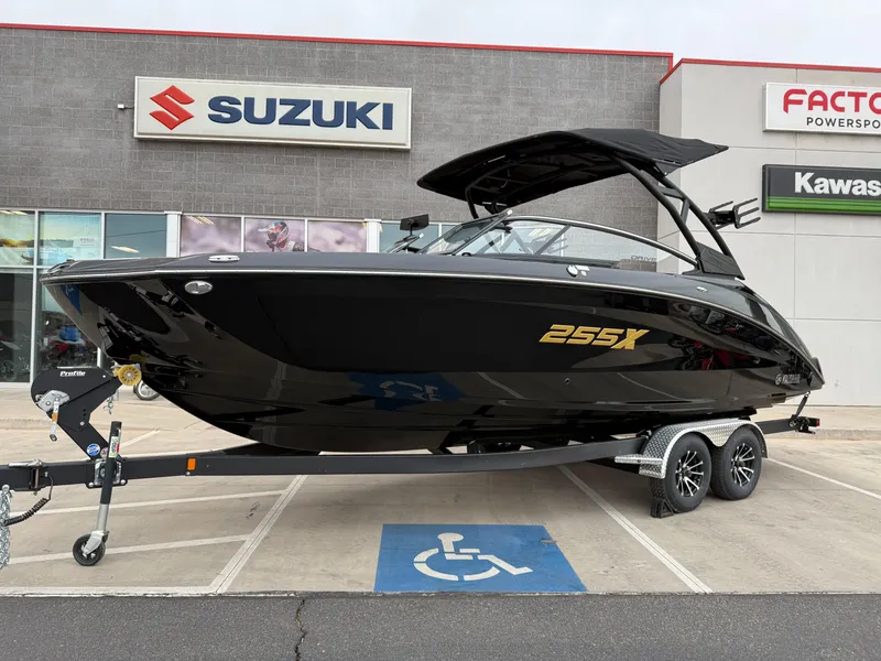 Slide: The Image of 2025 Yamaha Boats 255XD in black, displayed on a trailer outside a dealership. - 14