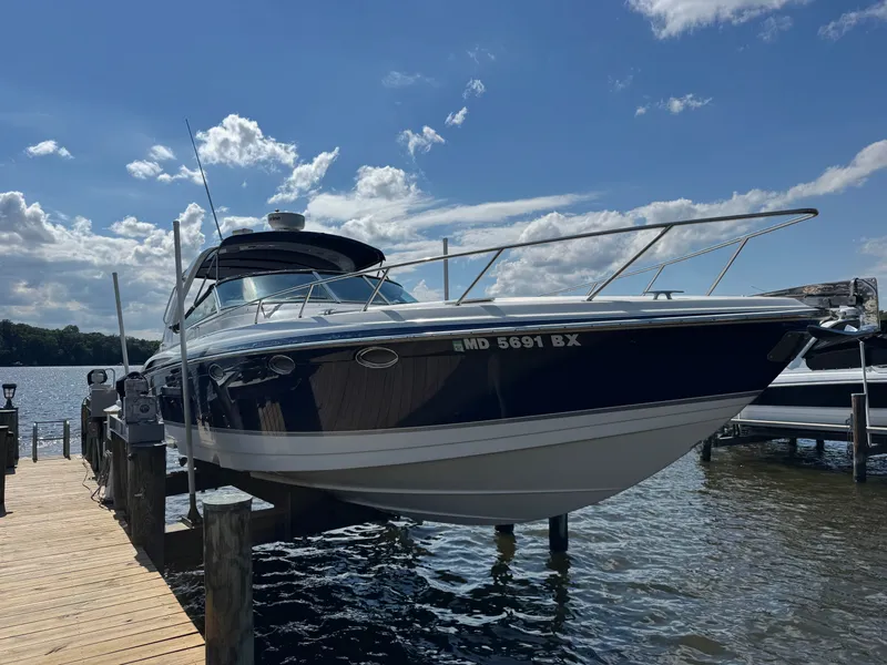 The Image of A blue and white motorboat docked at a wooden pier on the water. - 0