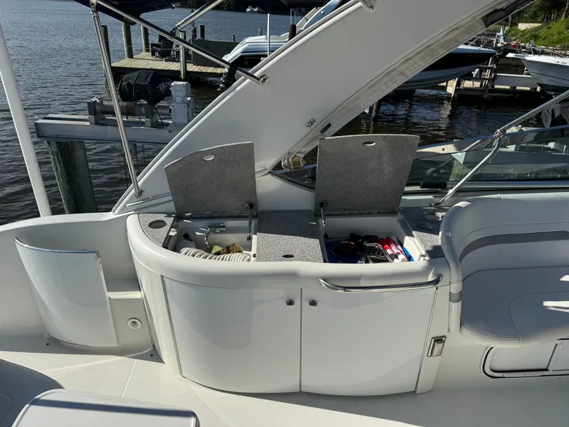 Slide: The Image of The boat has an open storage compartment with accessories, docked by the water. - 13