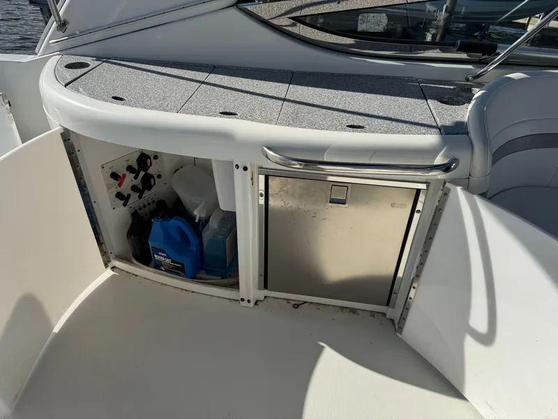 Slide: The Image of Open storage area on a boat with cleaning supplies and a refrigerator. - 14