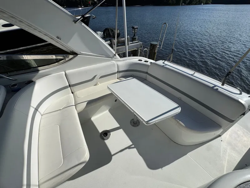Slide: The Image of A sleek boat with white seating and a table, docked by the water. - 15