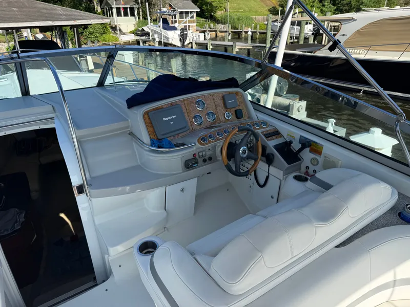 Slide: The Image of The cockpit of a white boat with a wooden dashboard and steering wheel. - 16