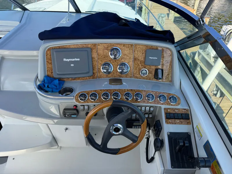 Slide: The Image of The cockpit of a boat with wood paneling and Raymarine screens. - 19