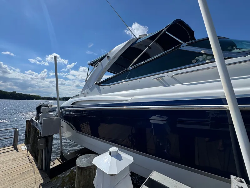Slide: The Image of A white and blue boat docked at a wooden pier under a blue sky. - 2