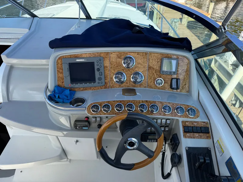 Slide: The Image of The cockpit of a boat with wood paneling and numerous instruments. - 20