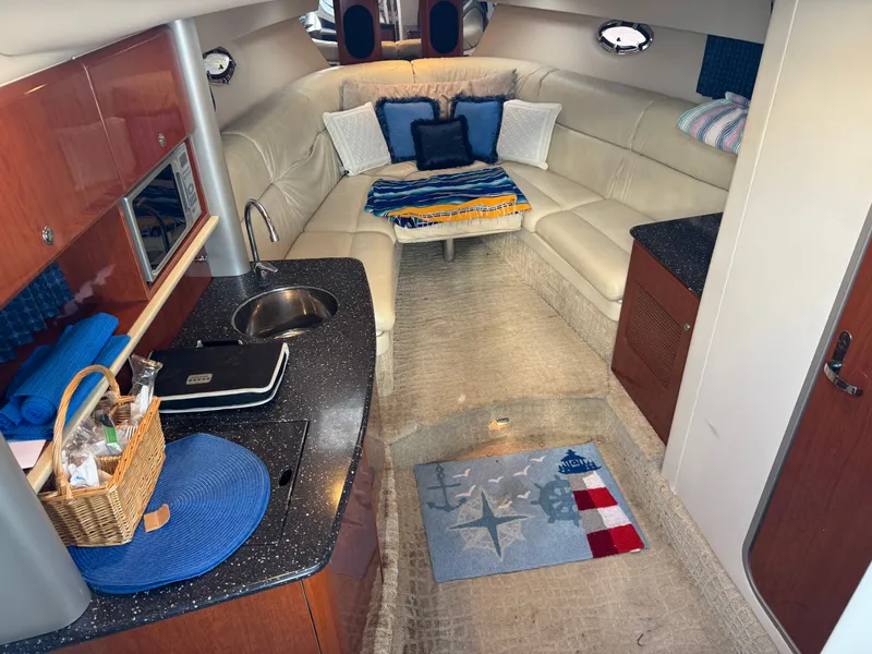 Slide: The Image of Interior of a yacht with a kitchenette, sofa, and decorative pillows. - 26