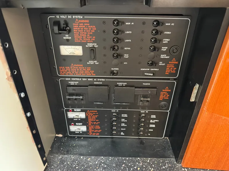 Slide: The Image of Electrical control panel system with warning labels and switches inside a boat. - 35