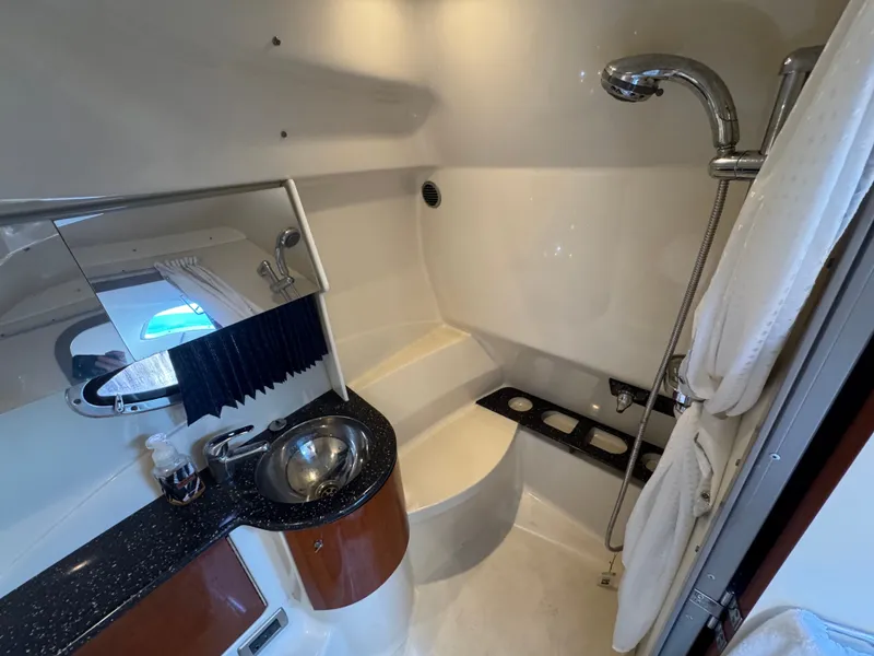 Slide: The Image of A sleek bathroom with a sink, mirror, and shower inside a boat. - 38