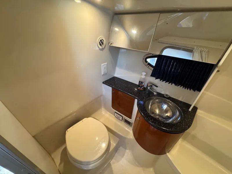 Slide: The Image of The bathroom of a yacht with a toilet, sink, and mirror. - 39