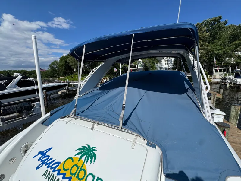 Slide: The Image of A boat with a blue cover docked at a sunny pier. - 4