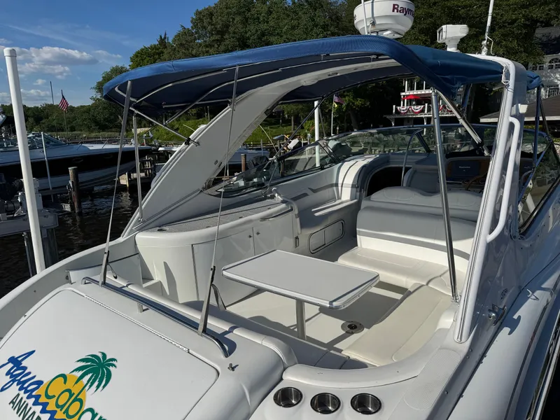 Slide: The Image of A white motorboat with a blue canopy and seating area docked at a marina. - 9